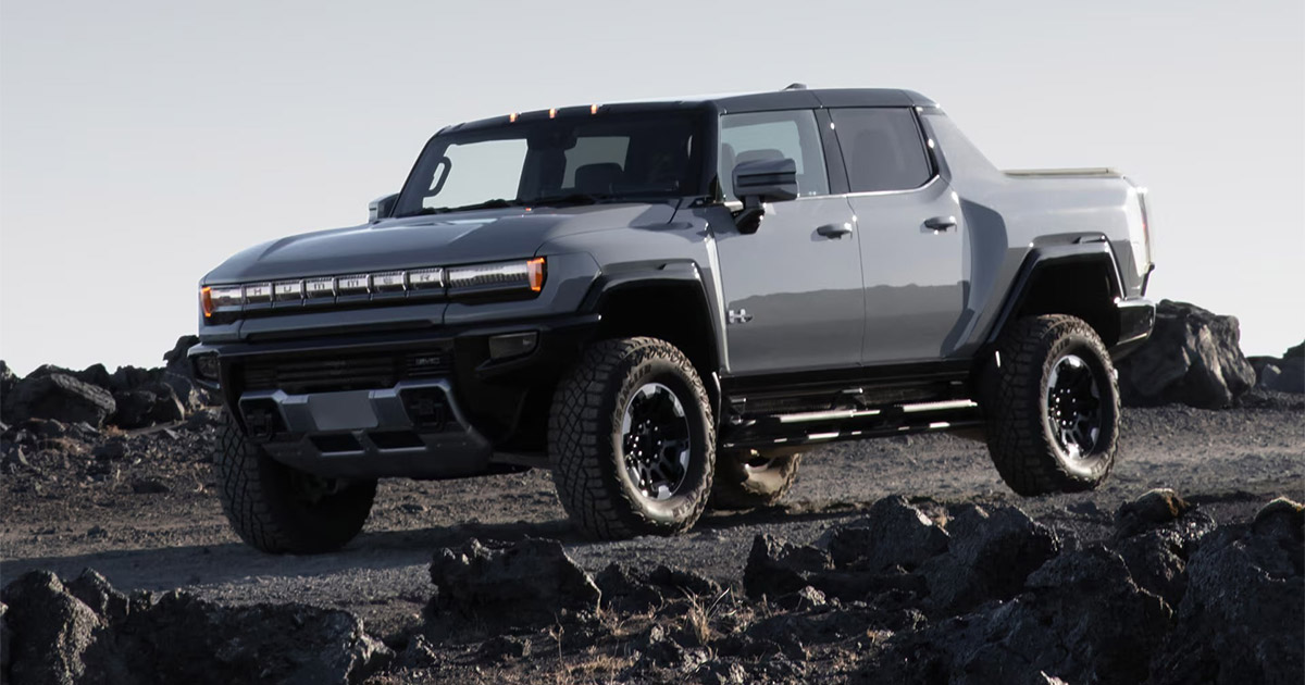 White and gray Hummer EV electric pickup truck on rocky terrain with rugged off-road wheels and powerful stance