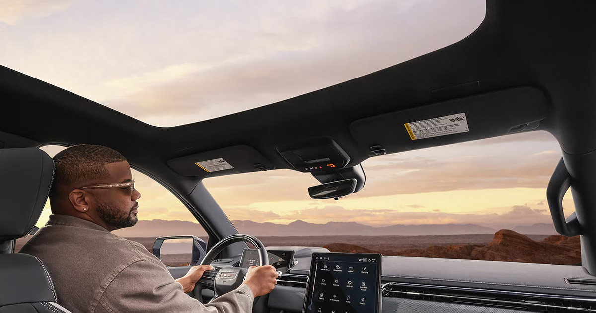 SUV driver at sunset, overlooking rocky desert landscape with modern vehicle interior visible