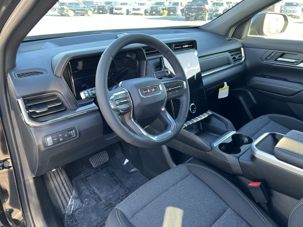 Image of the interior of the 2026 GMC Acadia showing off the front dashboard and infotainment system.