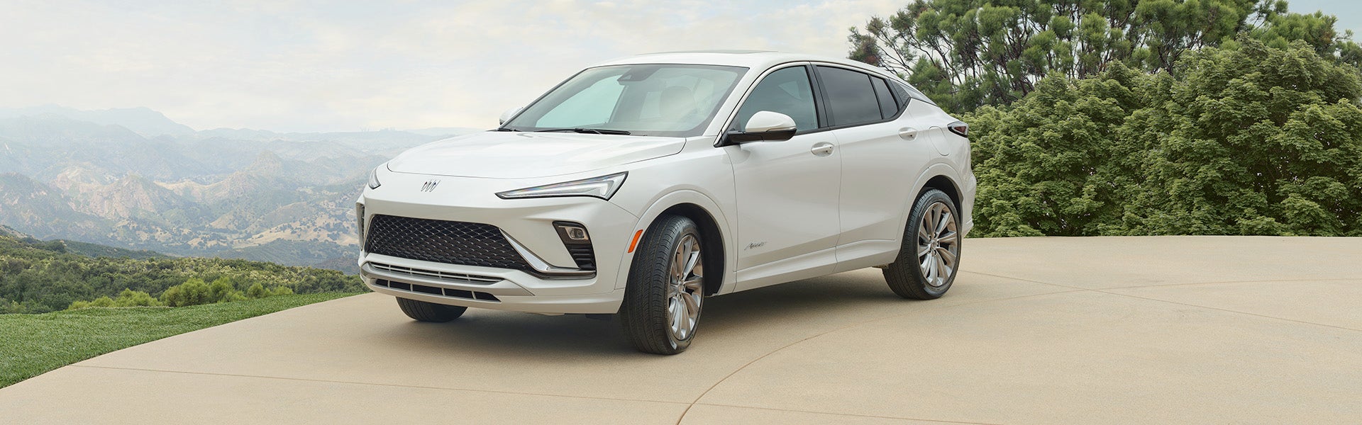 Red Buick Encore GX SUV rear view parked by a brick building