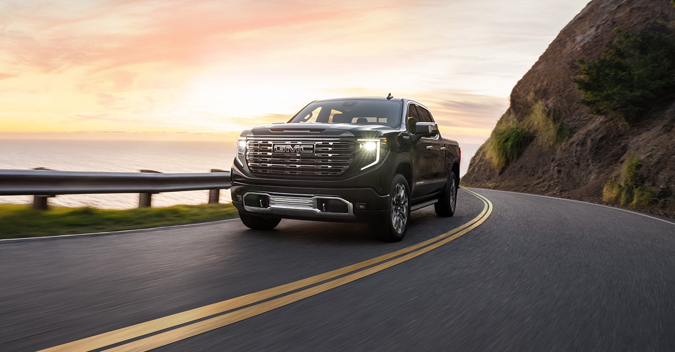 A Black GMC Sierra pickup truck driving on road